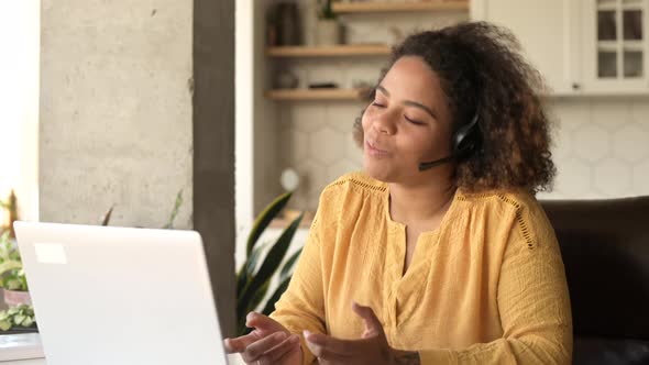 AfricanAmerican Woman Wearing Wireless Headset Using a Laptop for Video Call alt