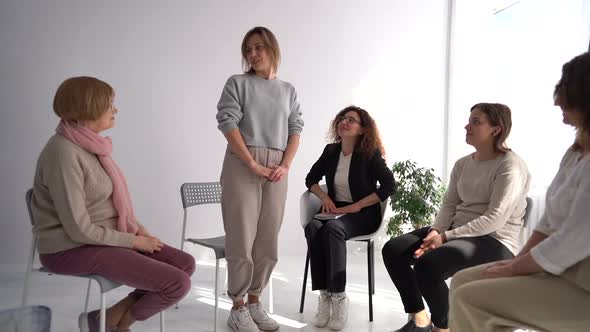 A Young Woman is Standing Up and Telling Her Story in a Psychotherapist's Office During Group alt