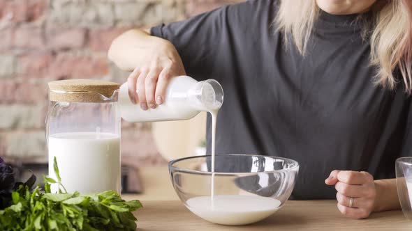 Faceless Woman Pours Milk From Glass Bottle