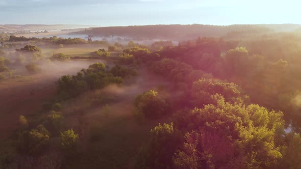 Aerial Drone View of Sunrise Over Misty River alt