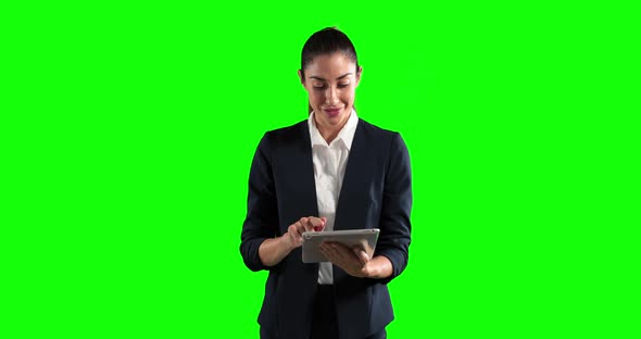 a Caucasian woman in suit using a tablet in a green background