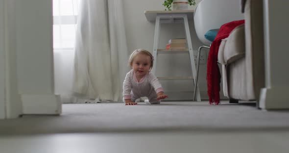 Close up of caucasian baby crawling on the floor at home alt