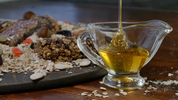 a Stream of Honey is Poured Into a Transparent Glass Saucepan