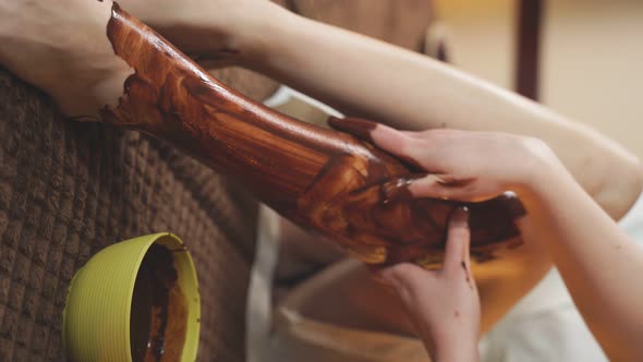 Closeup of Women s Legs Which are Covered with a Cosmetic Chocolate Mask alt