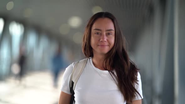 Portrait of Brunette Woman with Long Hair in Pedestrian Tunnel at Daytime alt
