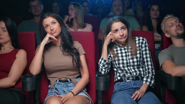 Two Female Spectators Watching Uninteresting Film Unpleasant Face Expression Sleeping Auditorium alt