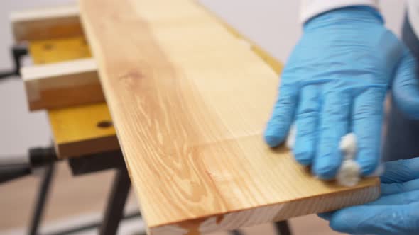 the Carpenter Rubs the Wood with Oil with a Napkin alt