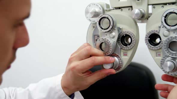 Optometrist adjusting phoropter alt