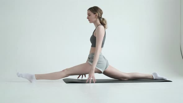 Young Fit Girl Doing Splits Exercise in Bright Room