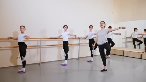 Group of Boys Students in Ballet School Repeat Exercise After Their Teacher