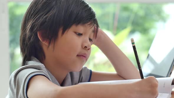 Asian Child Tired And Bored Of Doing Homework, Kid Stressed From Learning alt