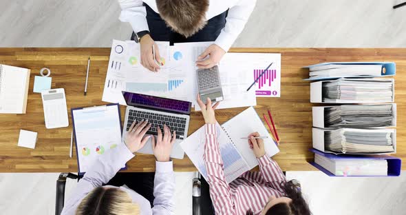 Team Collaboration with Business Charts and Calculator at Workplace alt