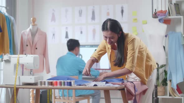 Asian Female Creates A Template Of The Future Dress While A Male Designing Clothes On The Desktop alt