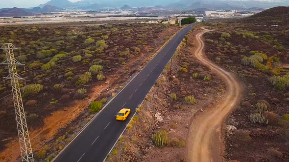 Top View of a Car Rides Along a Desert Road alt
