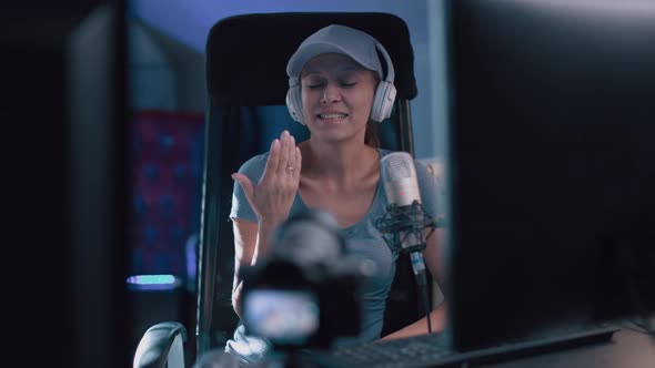 Beautiful Woman In A Cap And White Headphones Leads A Live Stream alt