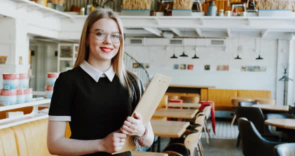 Smiling Waitress Girl in Empty Cafe Restaurant When It's Closed for Quarantine