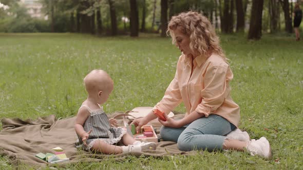 Woman and Little Girl Playing in Park alt