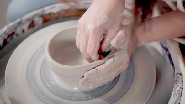 Woman Is Wetting and Softening Clay on Potter's Wheel in Pottery, Close-up alt
