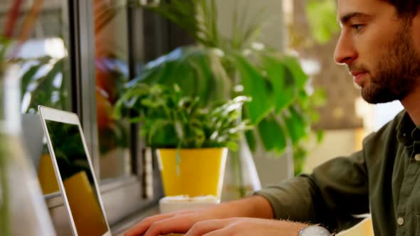 Close-up of handsome man using laptop at table 4k alt