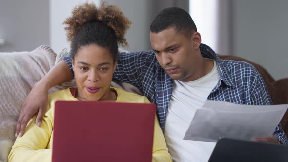 Focused African American Man Hugging Busy Woman Typing on Laptop Keyboard alt