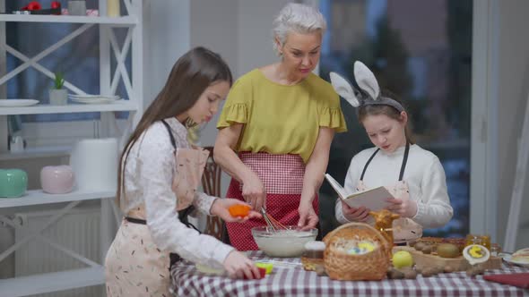 Confident Woman Mixing Bakery Ingredients As Girls Reading Recipe Preparing Baking Forms alt