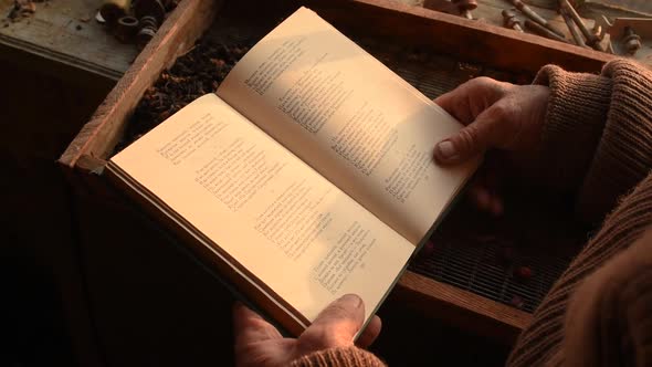 Man Glasses Picks Up Old Book in Dust Read in House Window alt