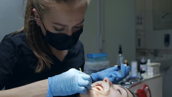 Young Woman Dentist Applies Gel on Patient's Teeth in Modern Dentistry