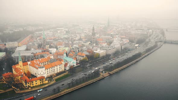 Amazing Aerial Cityscape Panorama of Riga Old Town and Car Traffic Along River Daugava Under Fog on alt
