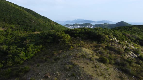 Aerial revealing shot showing binh hung island behind green mountains in Vietnam alt