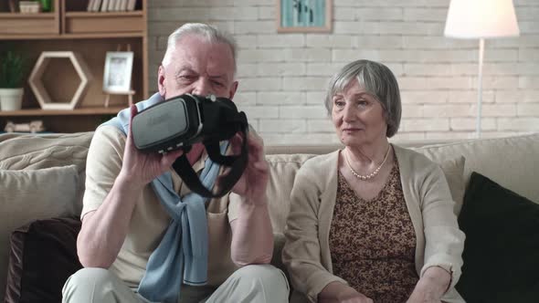 Senior Couple Inspecting VR Headset alt
