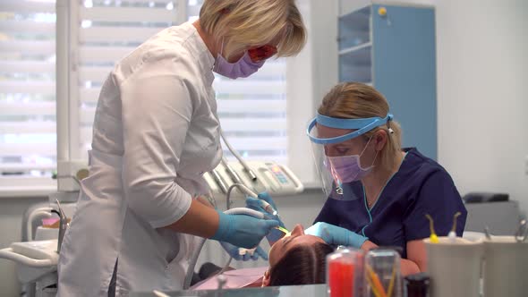 Female Dentist at Work with Assistant