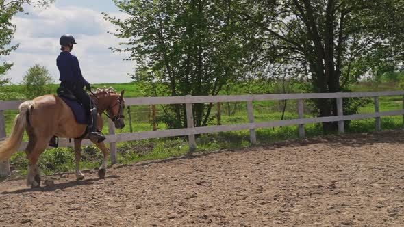 Female Jockey Wearing Helmet Riding On A Pearl Horse Moving In The Sandy Parkour alt