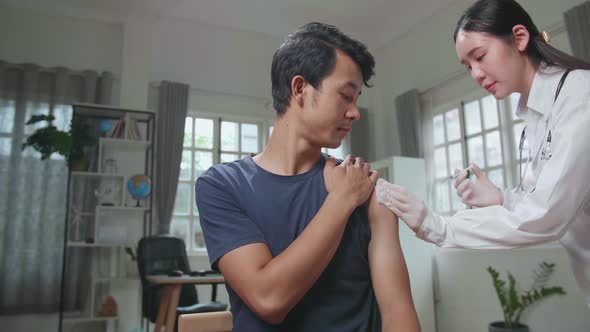 Medical Nurse In Safety Gloves Is Making A Vaccine Injection To A Male Patient In A Health Clinic alt