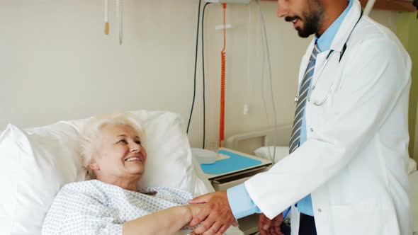 Doctor consoling senior patient alt