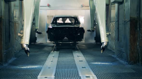 Automotive Painter Robots Painting a Car Body at a Car Production Factory alt