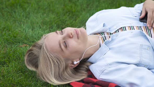 Top View of Happy Blonde Woman Listening to Music in The Headphones