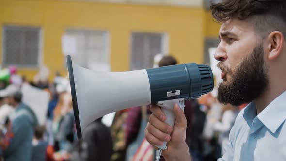 Young Adult Man Shouts in Megaphone. He Screams Violently and Angry Slow Motion alt