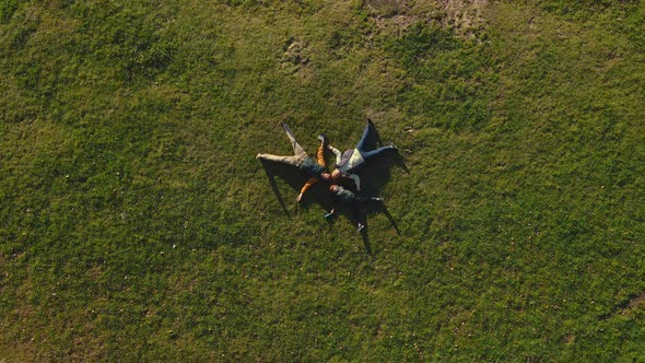 A Family of Three Father Mother and Son are Lying on the Grass in a Park alt