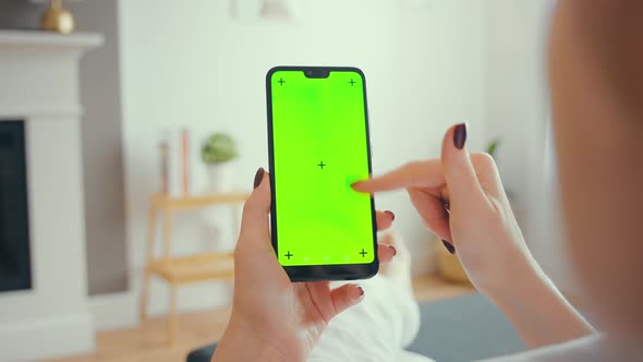 Young Female Using Smart Phone Sitting On Sofa At Home.