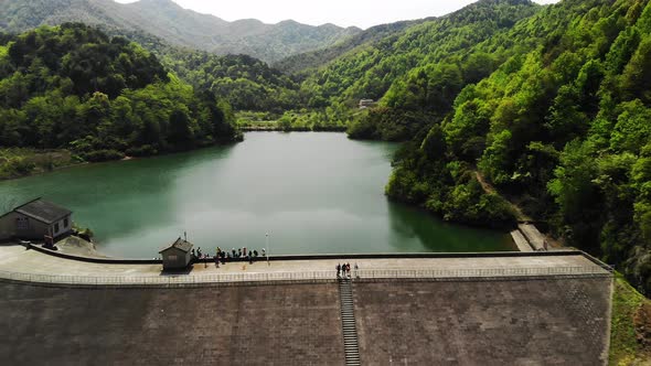 Aerial View a Dam with Green Mountains and Some People