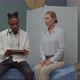 Doctor Explaining Diagnosis Using Tablet to Female Patient Indoors - VideoHive Item for Sale