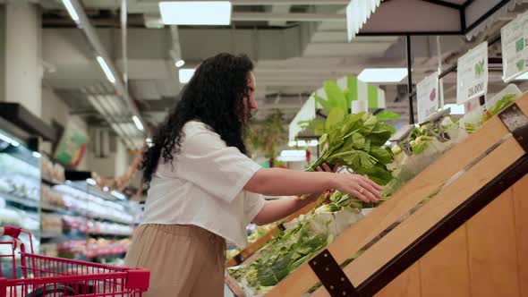 Attractive Young Woman a Chooses Cabbage Salad Makes Purchases in the Supermarket Buys Groceries alt
