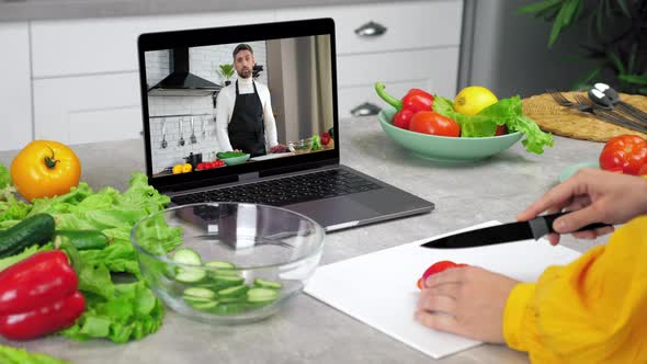 Woman in Kitchen Study Online Cooking Course Slices Tomato Listen Chef Teacher alt