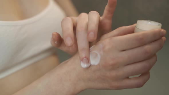 A Woman Smears a Hand Cream Closeup alt