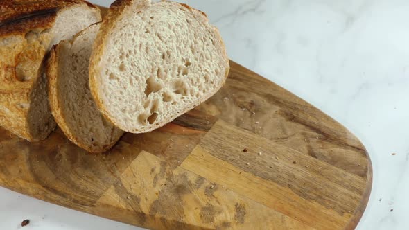 Piece of Fresh Bread Falls on a Cutting Board