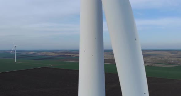 Rotating Wind Turbine Blades in Close Up Ascending Aerial Drone View alt