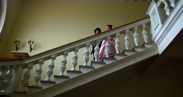 A Couple From 18Th Century Is Walking Down the Stairs at the Ball, Talking,  alt