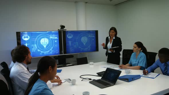 Doctor interacting with colleagues in meeting alt
