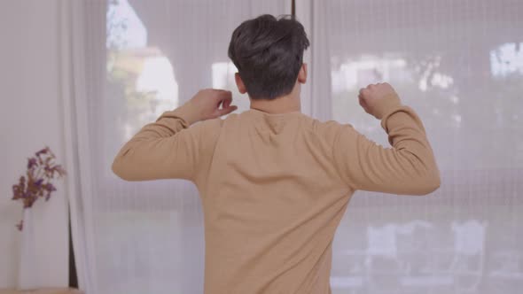 Asian Man Waking Up in Bed Smilling in Morning. Man at Home in Bed Stretching. Lifestyle Concept