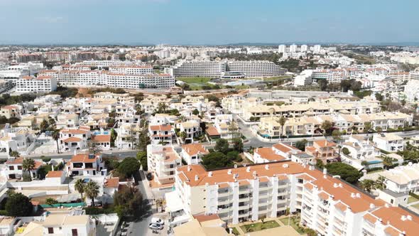 4k drone footage panning the horizon, revealing the popular coastal resort town of Albufeira alt